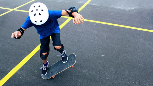  A kid riding a skateboard with a helmet on